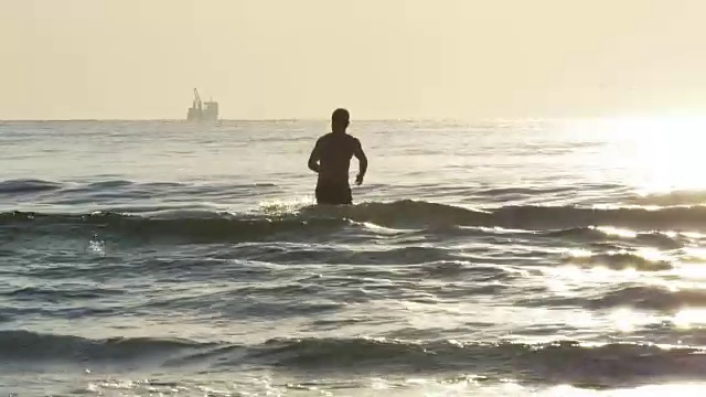 年轻的雄性在海里游泳视频素材