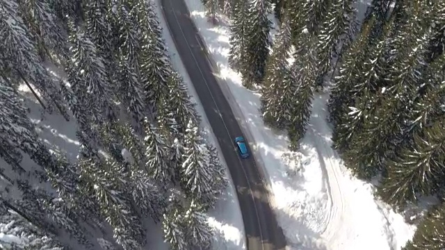 空中摄影:汽车穿过神奇的冰雪云杉森林在冬季仙境视频素材