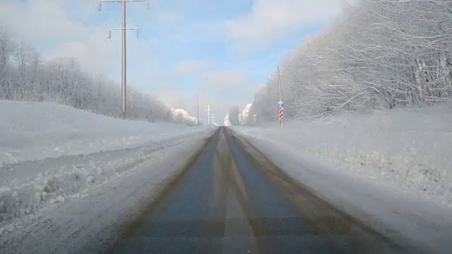 在下雪的乡村道路上驾驶POV。冬季雪山公路驾驶。森林视频素材