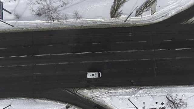 空中驾驶-汽车在六车道的道路上通过雪景视频素材