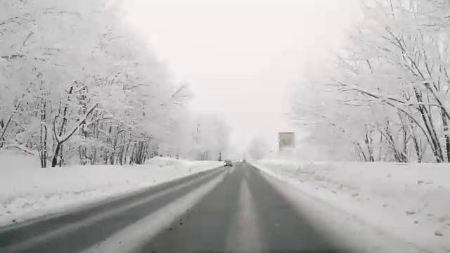 在下雪的乡村道路上驾驶POV。冬季雪山公路驾驶。森林。驾驶时间流逝的hyperlapse视频素材