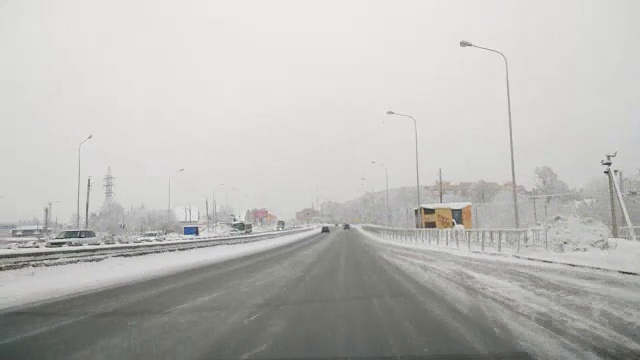 在雪地上驾驶POV。暴风雪驱赶城市街道的速度很快。冬季暴风雪来袭。在积雪和结冰的道路上危险的驾驶条件。视频素材