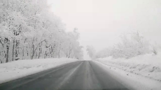 在下雪的乡村道路上驾驶POV。冬季雪山公路驾驶。森林。驾驶时间流逝的hyperlapse视频素材