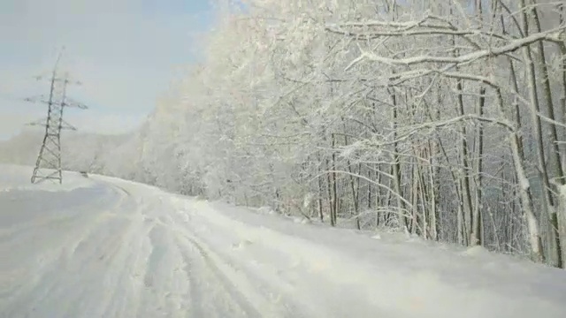 在下雪的乡村道路上驾驶POV。冬季雪山公路驾驶。森林视频素材