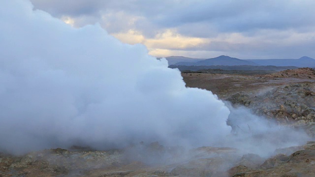 巨大的白色蒸汽从大地中抽出，风景如画的大地、山、天空视频素材