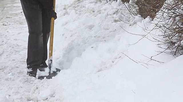 用铲子铲雪的人视频素材