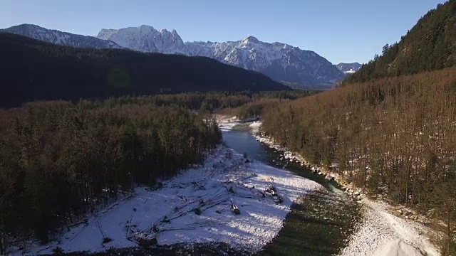 在阳光明媚的日子里，空中的河流在冬季积雪覆盖的山区森林里视频素材