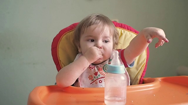 小男孩吃。可爱的婴儿在桌子上吃饭视频素材