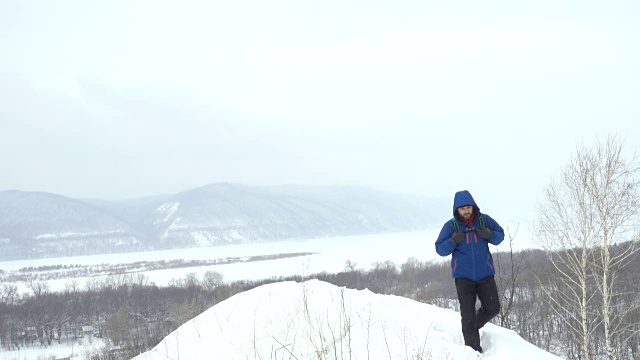 有胡子的徒步旅行者在雪地上向摄像机走去。徒步旅行探险登山旅行户外徒步旅行极限运动冷活动冰冬季景观天空自然跋涉登山高峰活动视频素材