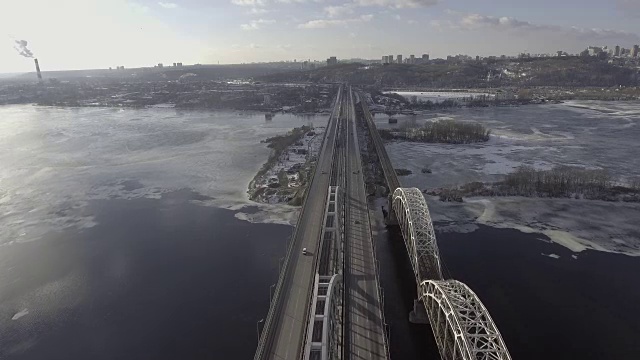 飞过铁路桥，在车底行驶时，河面已结冰，覆盖着积雪。机器去了东方视频素材