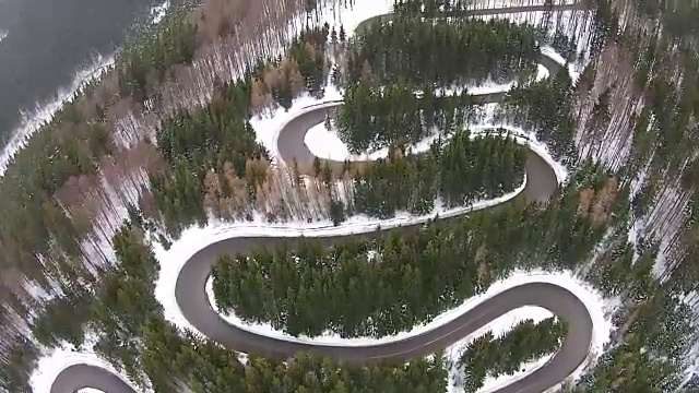 穿越山脊的公路有许多壮观的弯道，穿过冷杉林，冬季景色有雪景，鸟瞰图视频素材