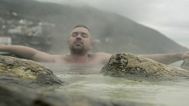 男子在度假村的海滩上泡温泉视频素材