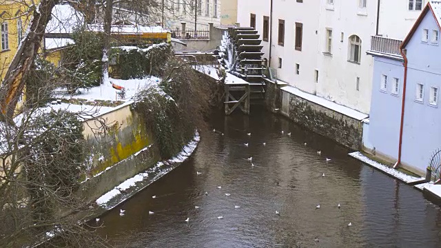 布拉格查尔斯桥附近的运河和水厂在冬天的雪下视频素材