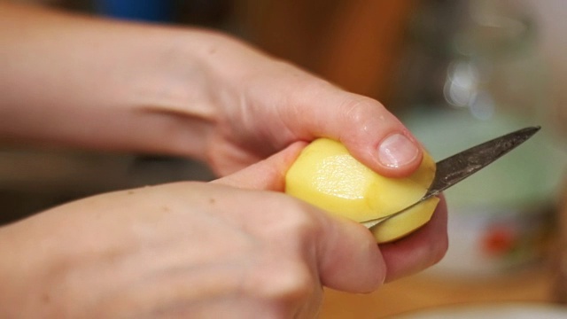 在家厨房削土豆皮。慢动作视频素材