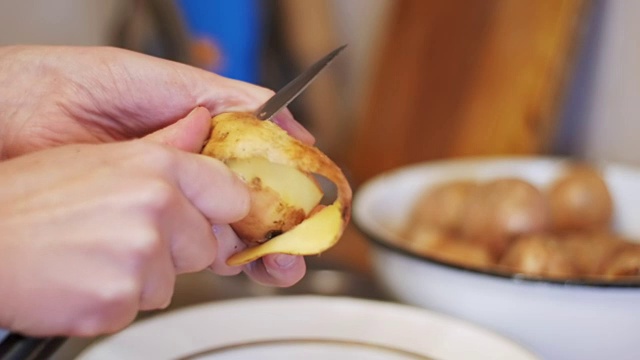 在家厨房削土豆皮。慢动作视频素材