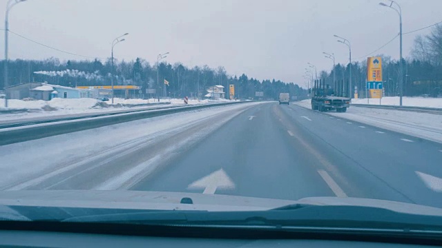 在白天冬天的路上开车。透过司机的挡风玻璃观看。视频素材