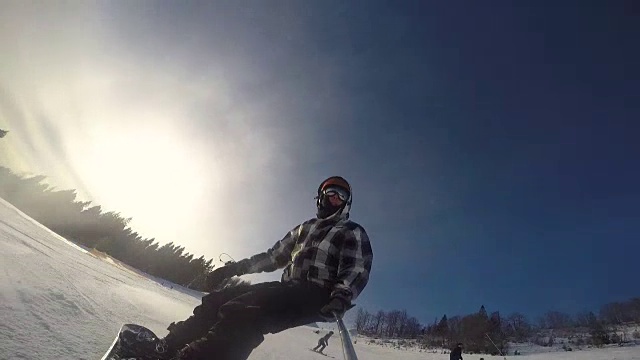 手持自拍杆，骑着滑雪板的男子视频素材