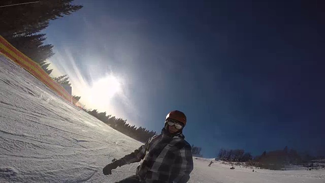 自拍:兴高采烈的单板滑雪爱好者在阳光明媚的冬日里，在雪山的偏远地区玩单板滑雪。极限免费滑雪滑雪板骑新粉雪和做粉转弯雪道视频素材