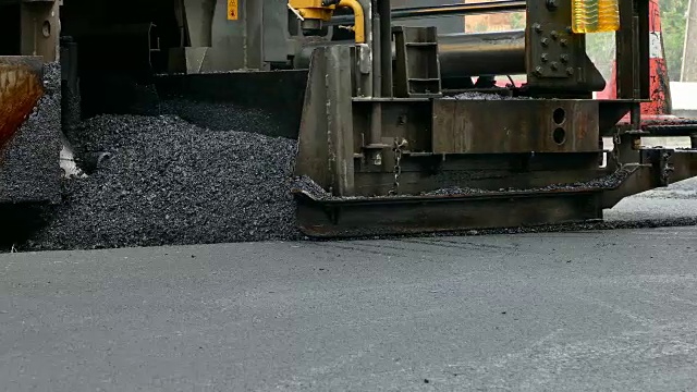 沥青摊铺机在公路上铺沥青。沥青路面自动铺沥青的设备。视频素材