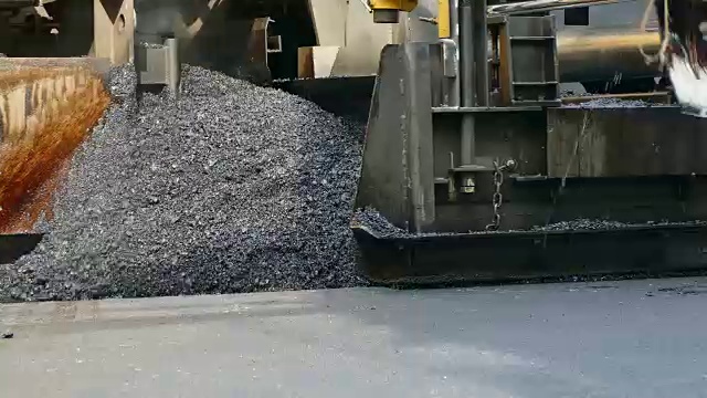 沥青摊铺机在公路上铺沥青。沥青路面自动铺沥青的设备。视频素材