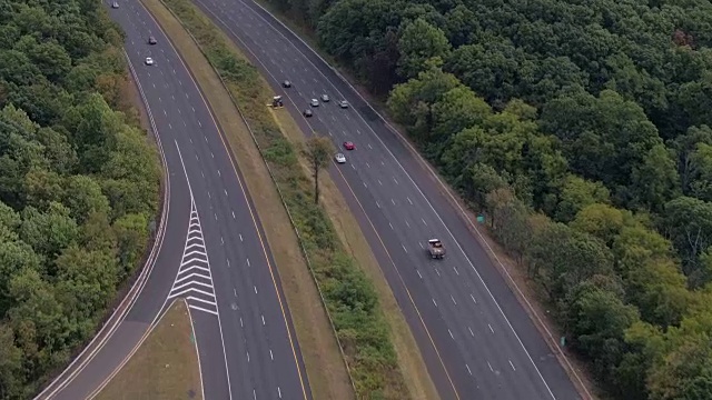 空中镜头:阳光明媚的日子里，半挂卡车和私家车在州际公路上飞驰视频素材