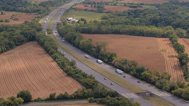 AERIAL:穿过农田，田野和森林的国家州际公路视频素材