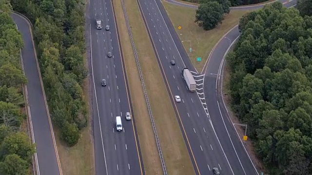 空中镜头:早上在州际公路上飞驰的半卡车和私家车视频素材