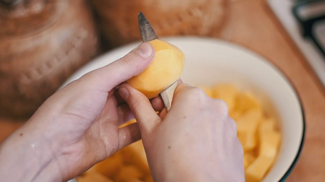 在家厨房削土豆皮。慢动作视频素材