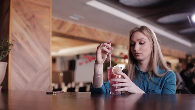 酒保端上鸡尾酒，漂亮女孩坐在吧台边视频素材