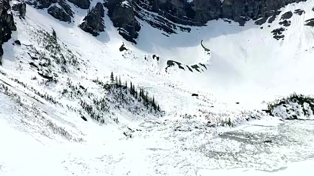 空中飞行:飞越结冰的湖面和雪崩碎片视频下载