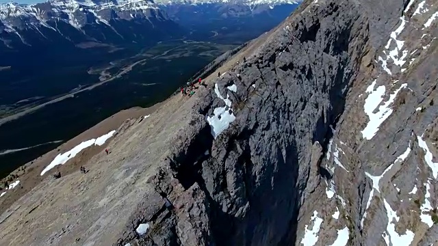 空中:绕着准备跟随陡峭山脊的徒步旅行者旋转视频素材