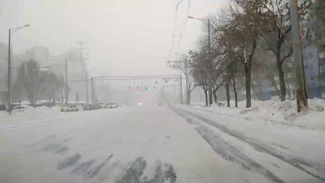 在雪地上驾驶POV。暴风雪驱赶城市街道的速度很快。冬季暴风雪来袭。在积雪和结冰的道路上危险的驾驶条件。视频素材