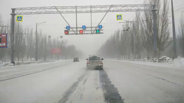 在雪地上驾驶POV。暴风雪驱赶城市街道的速度很快。冬季暴风雪来袭。在积雪和结冰的道路上危险的驾驶条件。视频素材