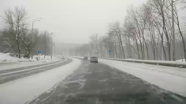 在下雪的乡村道路上驾驶POV。冬季雪山公路驾驶。森林。开车时间流逝视频素材