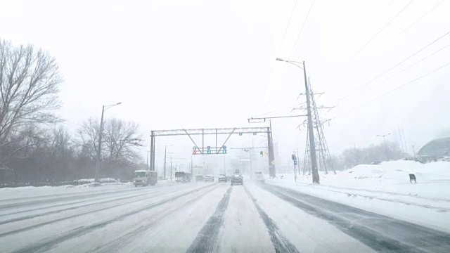 在雪地上驾驶POV。暴风雪驱赶城市街道的速度很快。冬季暴风雪来袭。在积雪和结冰的道路上危险的驾驶条件。视频素材