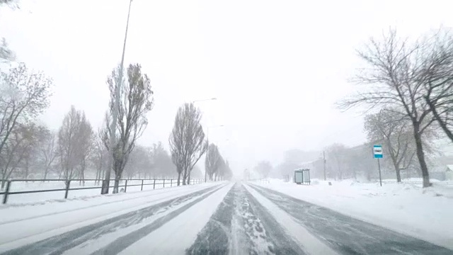 在雪地上驾驶POV。暴风雪驱赶城市街道的速度很快。冬季暴风雪来袭。在积雪和结冰的道路上危险的驾驶条件。视频素材