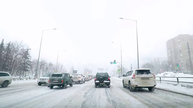 在雪地上驾驶POV。暴风雪驱赶城市街道的速度很快。冬季暴风雪来袭。在积雪和结冰的道路上危险的驾驶条件。视频素材