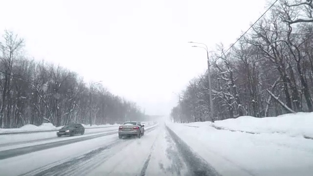 在雪地上驾驶POV。暴风雪驱赶城市街道的速度很快。冬季暴风雪来袭。在积雪和结冰的道路上危险的驾驶条件。视频素材