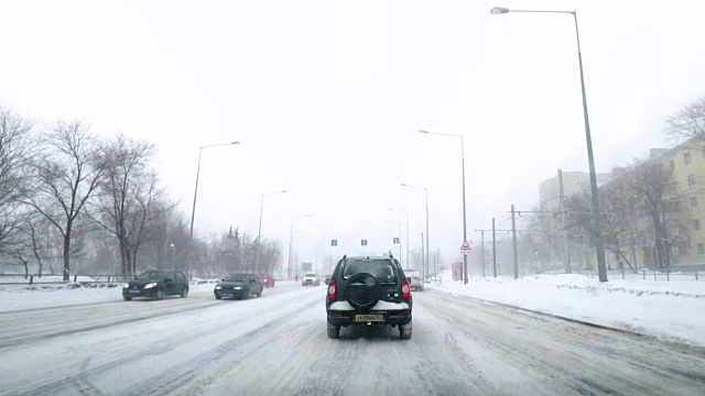 在雪地上驾驶POV。暴风雪驱赶城市街道的速度很快。冬季暴风雪来袭。在积雪和结冰的道路上危险的驾驶条件。视频素材