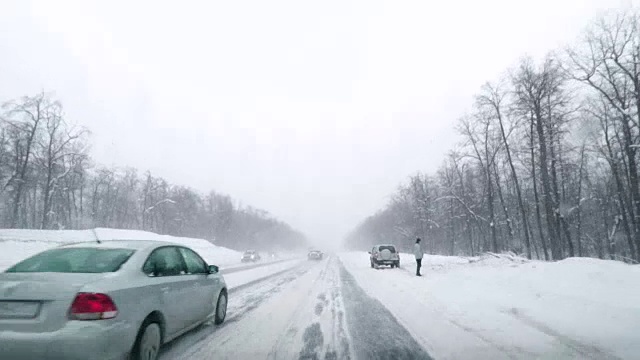 在下雪的乡村道路上驾驶POV。冬季雪山公路驾驶。森林。开车视频素材