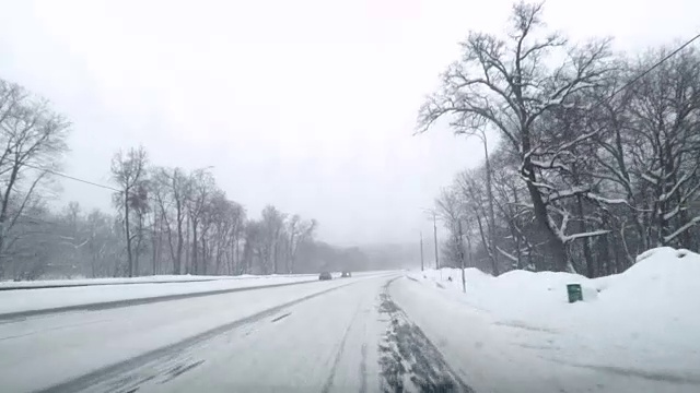 在下雪的乡村道路上驾驶POV。冬季雪山公路驾驶。森林。开车视频素材