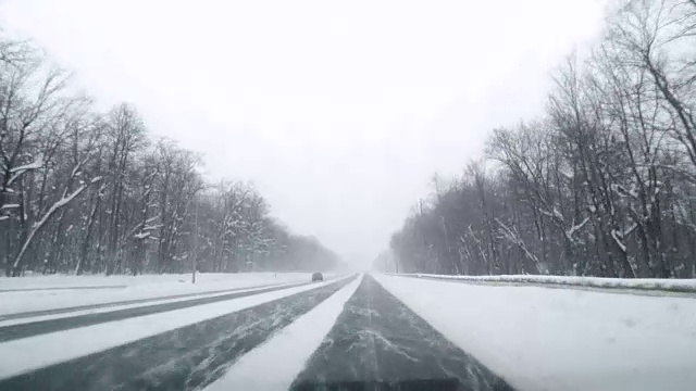 在下雪的乡村道路上驾驶POV。冬季雪山公路驾驶。森林。开车视频素材