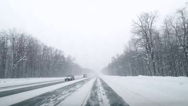 在下雪的乡村道路上驾驶POV。冬季雪山公路驾驶。森林。开车视频素材