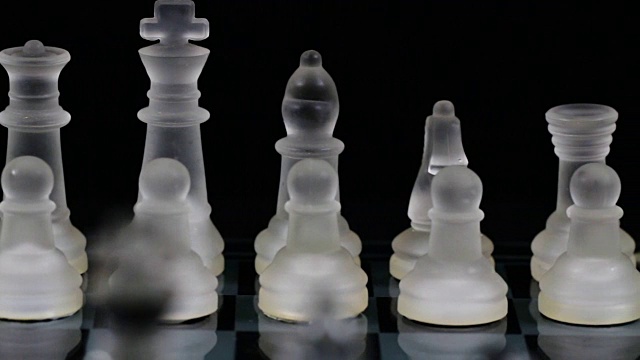 近镜头的玻璃棋子设置在远的一边的棋盘视频素材