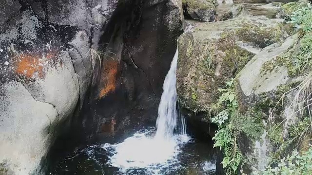 瀑布中等高度白色的水在深棕色的岩石背景视频素材