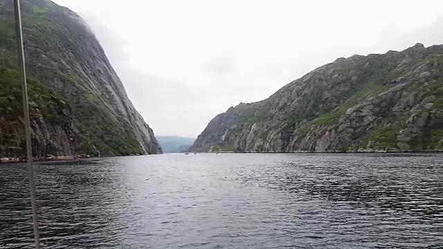 多云天气下，从游艇板上俯瞰在平静水域航行的巨峡湾。视频素材