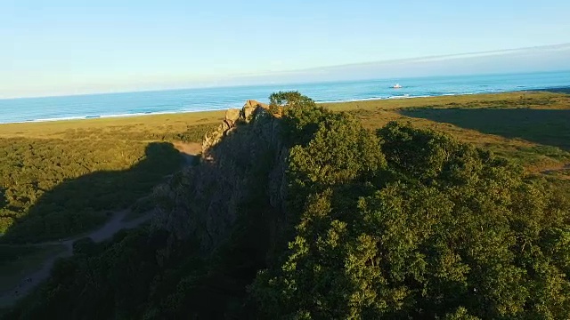 鸟瞰图。飞过一片阳光明媚的森林，树上有一块岩石。航空摄影机镜头。背景。视频素材