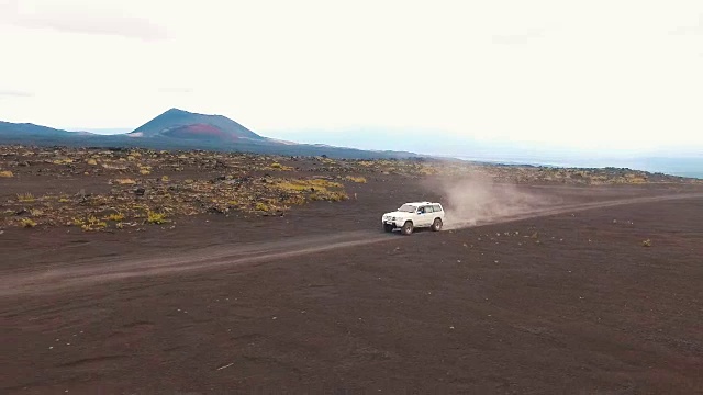 吉普车在火山附近行驶。盘旋到直升机越野车。火山喷发视频素材