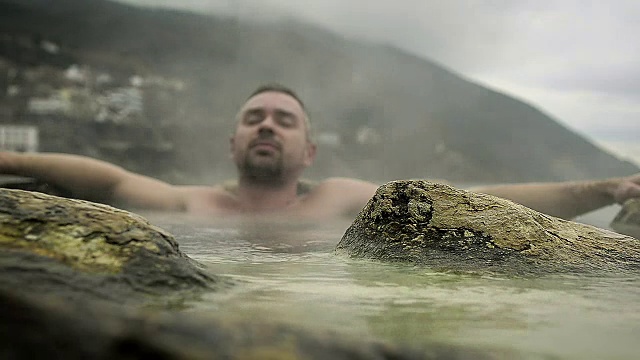 一名年轻人在度假村的海滩上洗热矿泉浴视频素材