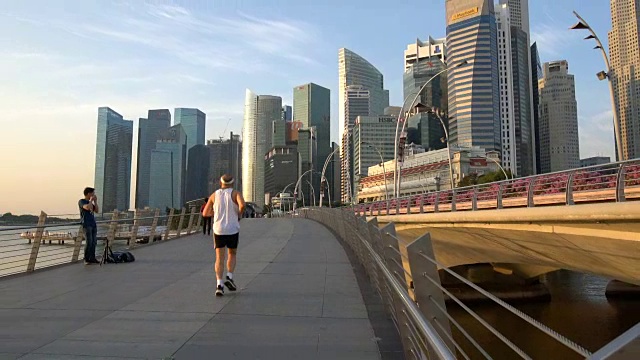 在摩天大楼背景下，人们在新加坡滨海湾散步和跑步视频素材